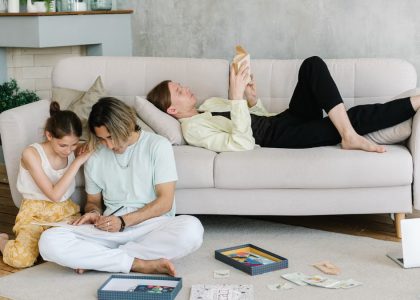 Father and daughter bonding in cozy living room with books and games, creating joyful family moments.